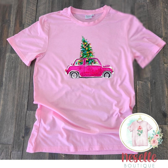 Pink car hauling a Christmas Tree